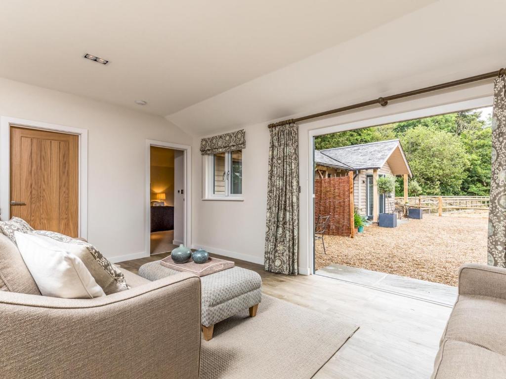 a living room with a sliding glass door to a yard at Pass the Keys Delightful 2Bed Lodge in Downland Village in Chichester