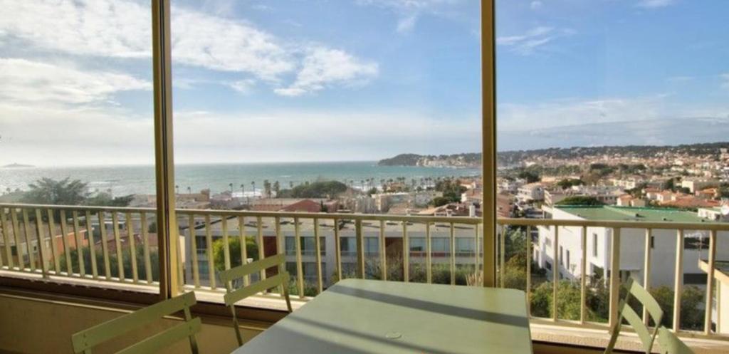 a balcony with a view of a city and the ocean at Charming Studio With Terrace And 180 Sea View in Six-Fours-les-Plages