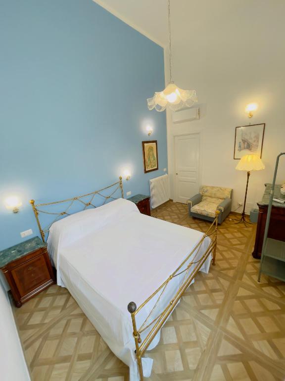 a bedroom with a white bed and a chair at Coco's Apartment in Meta
