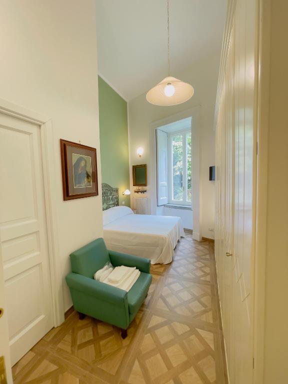 a bedroom with a bed and a green chair at Coco's Apartment in Meta
