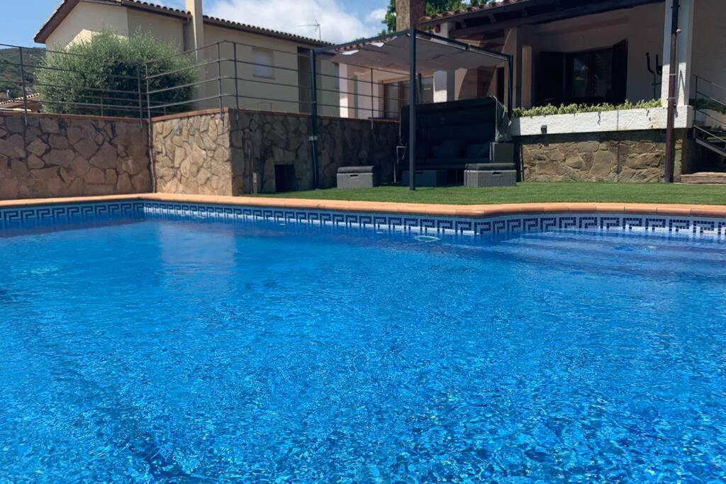 卡隆赫的住宿－Casa con piscina en la Costa Brava，一座大蓝色游泳池,位于房子前