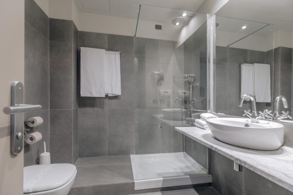 łazienka z 2 umywalkami i lustrem w obiekcie Hotel Continental w mieście Cremona