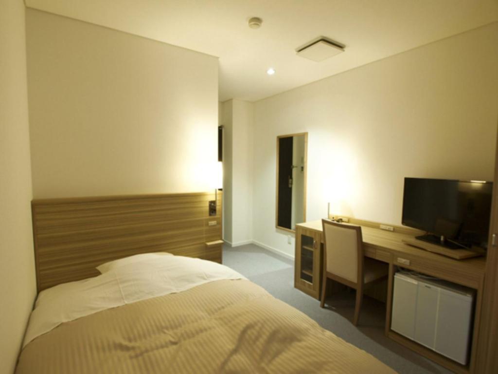 a bedroom with a bed and a desk with a television at Pure Hotel - Vacation STAY 44183v in Yabu