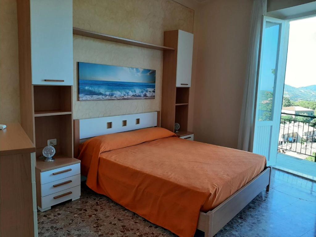 a bedroom with a bed and a large window at APPARTAMENTO CASA MARCO in Capoliveri