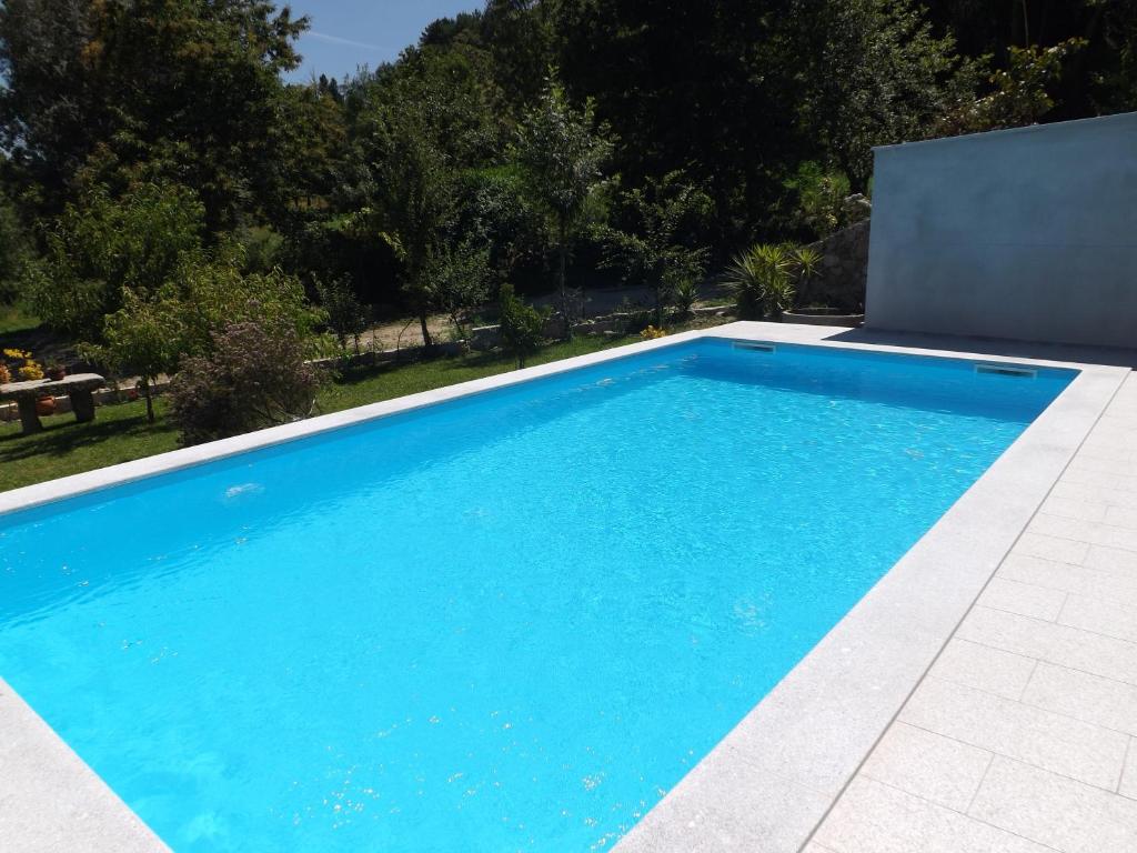 a swimming pool with blue water in a yard at Casa Oliveira in Grovelas