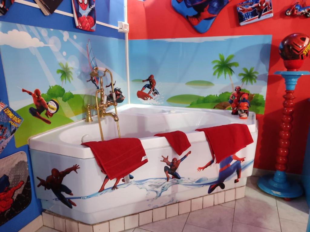 a bathroom with a bath tub with superheroes painted on it at Affitto breve Spider-man house in Catania