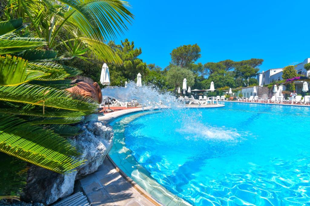 a swimming pool with a fountain in a resort at Hotel Pineta in Ischia