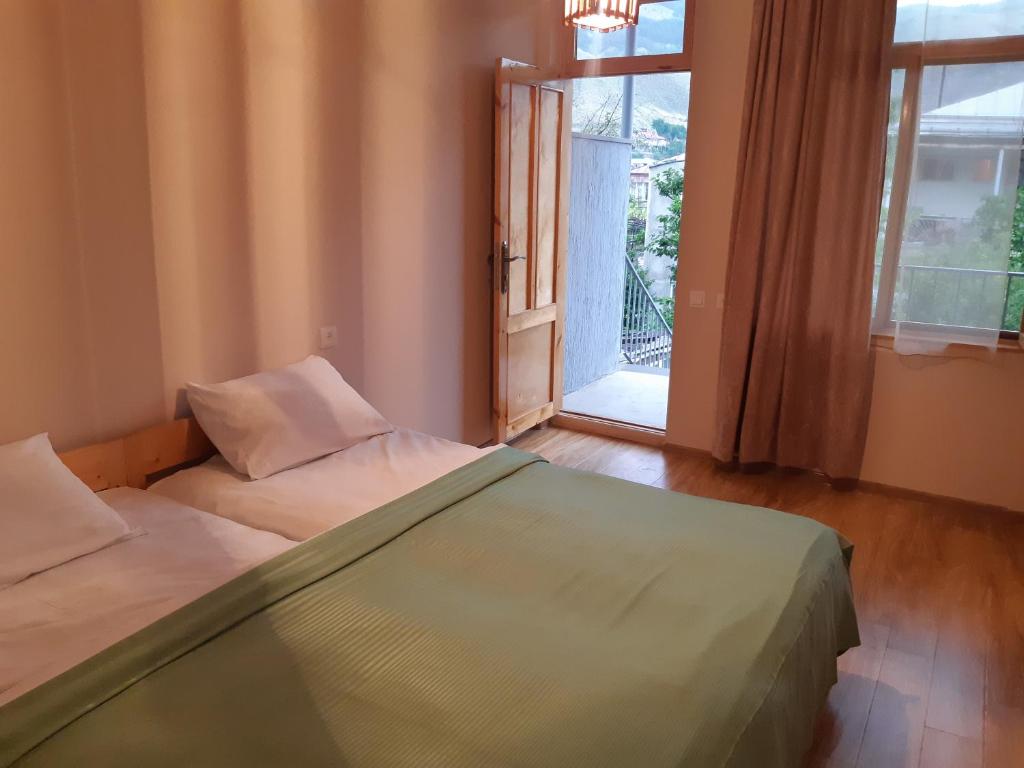 a bedroom with two beds and a large window at Andranik B&B in Goris