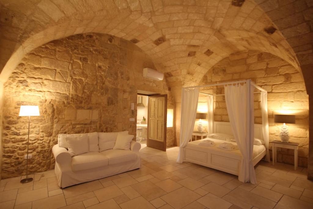 1 dormitorio con 1 cama y 1 silla en una pared de piedra en La Suite di Martina, en Lecce