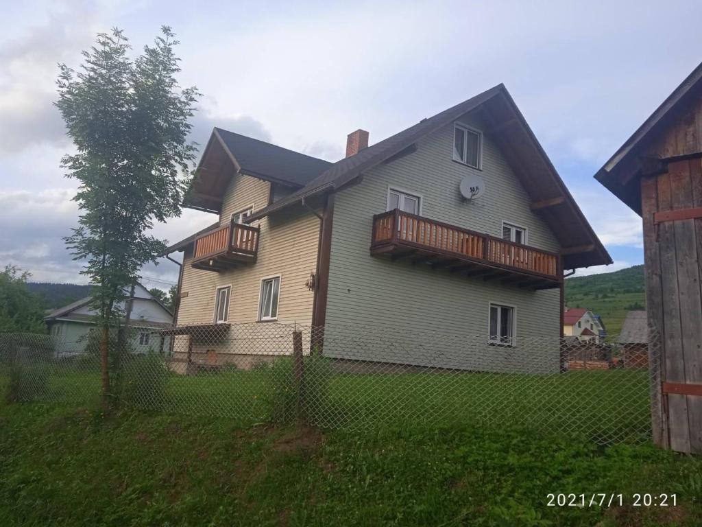 una casa grande con una valla delante en У Марка, en Volosyanka