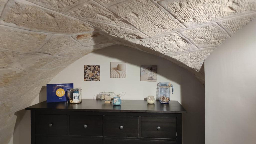 um quarto com uma cómoda de madeira sob um tecto de pedra em Al Fly em Monopoli