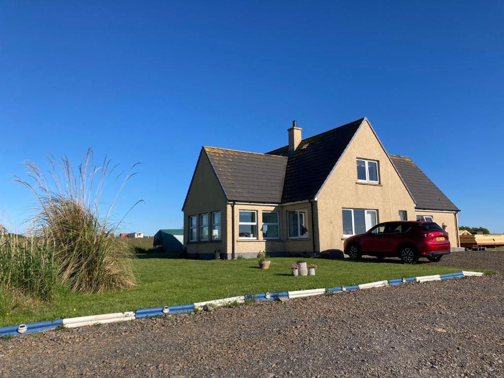 a house with a car parked in front of it at Alba Sunrise in Keiss