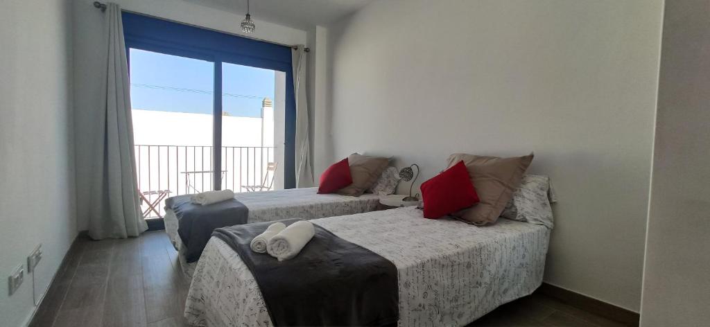 1 Schlafzimmer mit 2 Betten und einem großen Fenster in der Unterkunft Parking, ubicación y confort in Tarifa