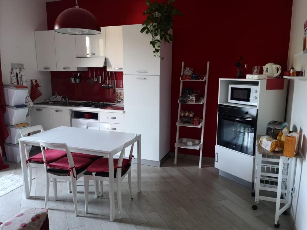 una cucina con tavolo bianco e pareti rosse di Da Felicia a Cossato