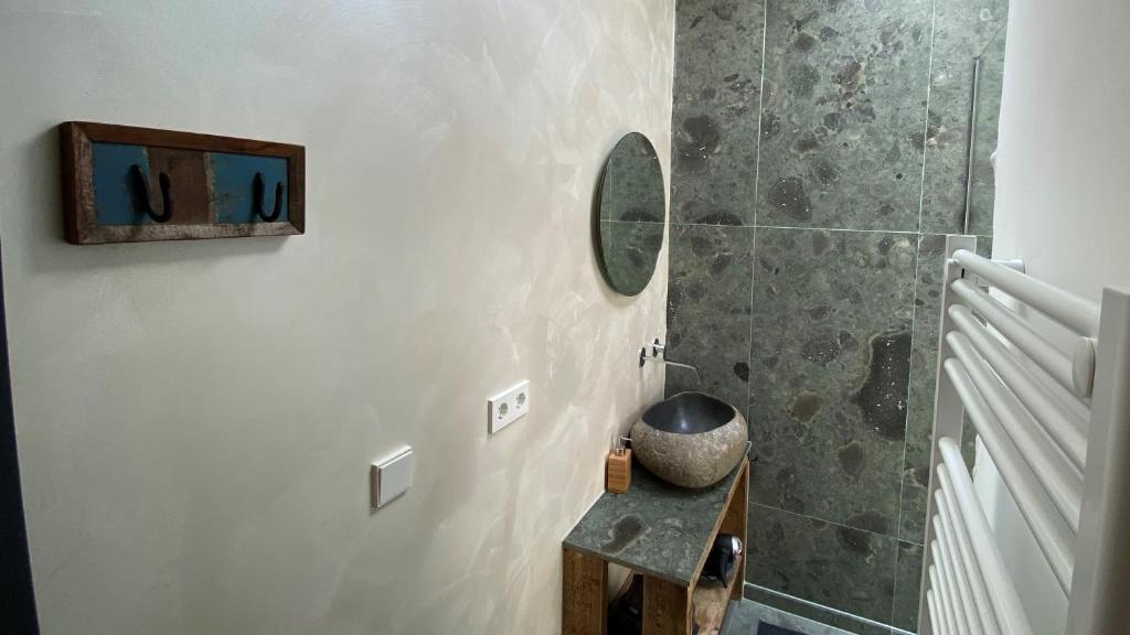 a bathroom with a shower and a table with a mirror at Het Lichthuis in Zandvoort