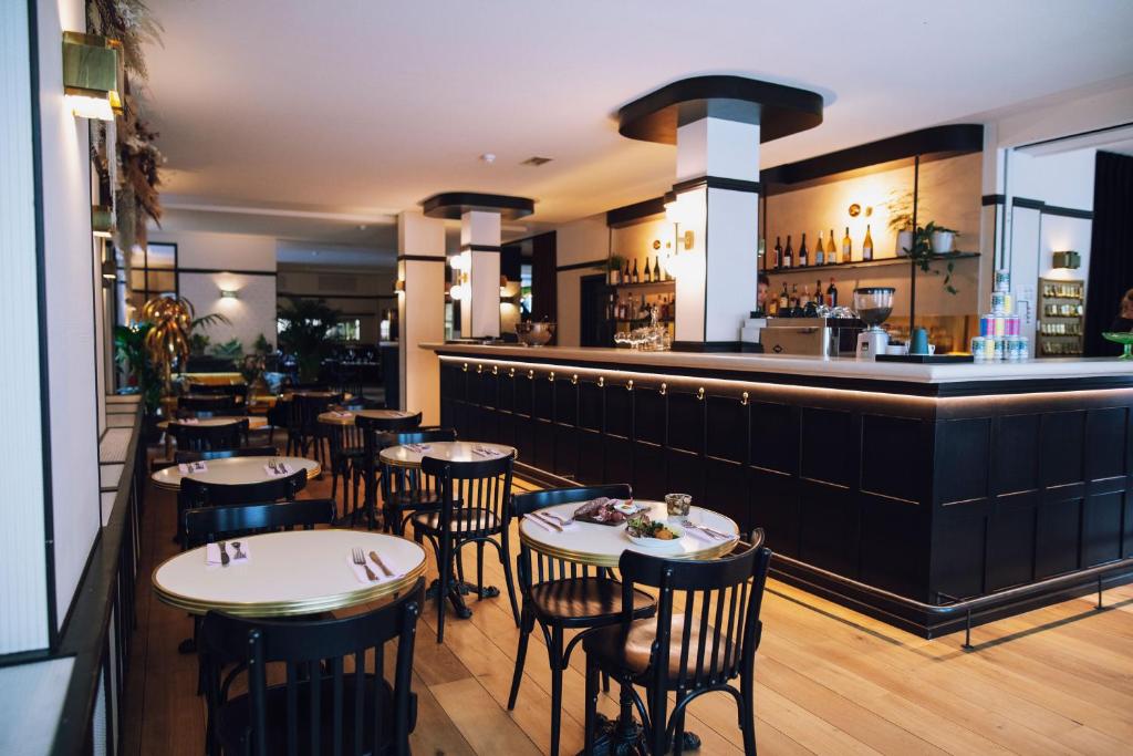ein Restaurant mit Tischen und Stühlen und eine Bar in der Unterkunft Latroupe Hotel Le Berger in Brüssel