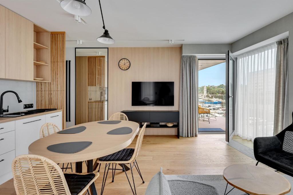 eine Küche und ein Wohnzimmer mit einem Tisch und Stühlen in der Unterkunft Marina View - Yacht Park Premiere in Gdynia