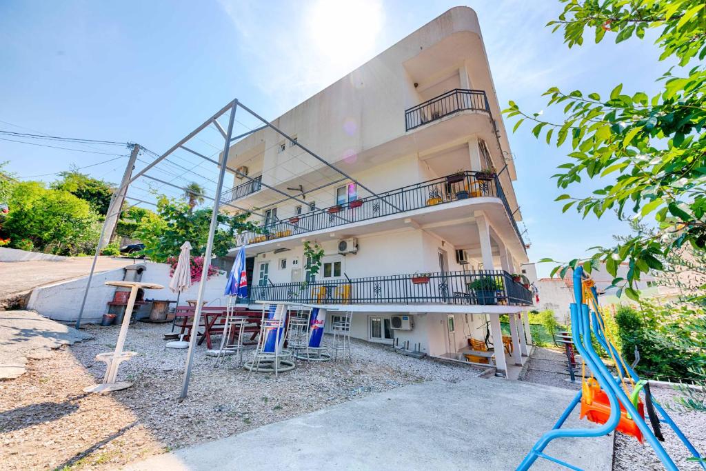 a building with a balcony and chairs in front of it at Apartments Glavanović in Bar