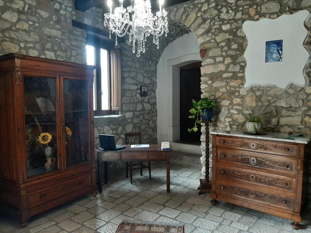 Habitación con escritorio de madera y lámpara de araña. en ANTICO FRANTOIO, en Piaggine