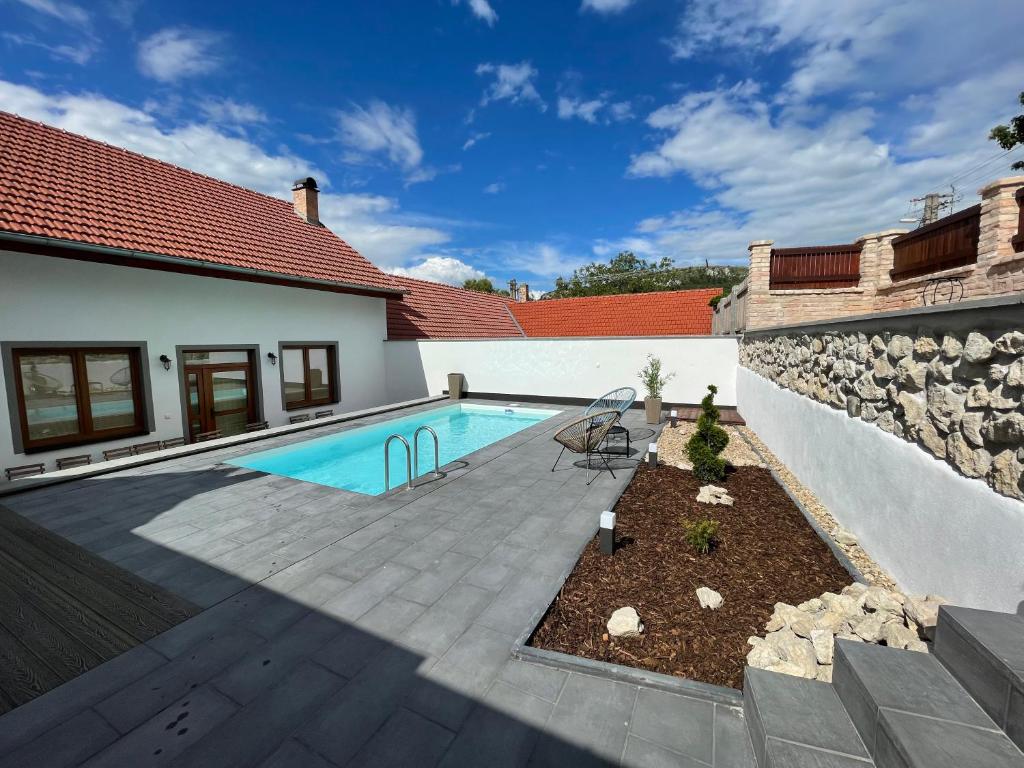 a backyard with a swimming pool and a stone wall at Summerhouse penzion Bavory in Bavory