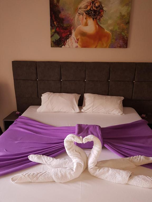 Una cama con dos cisnes en forma de corazón en Venus Sea View Apartment, en Perivólion