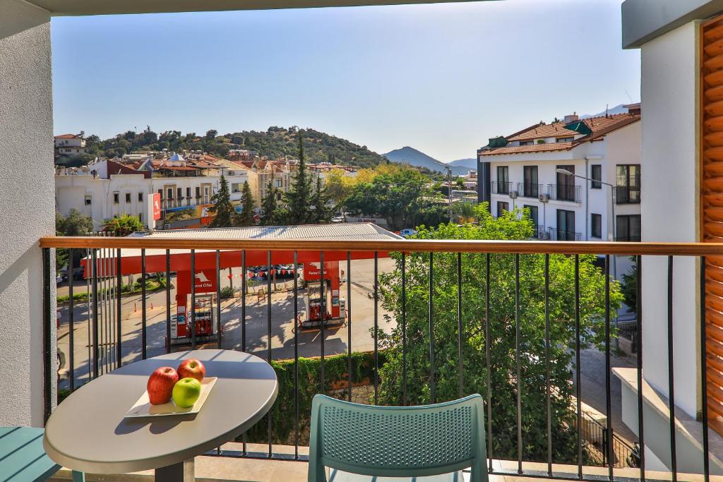 a balcony with a table and fruit on a tray at Neva Kaş in Kaş