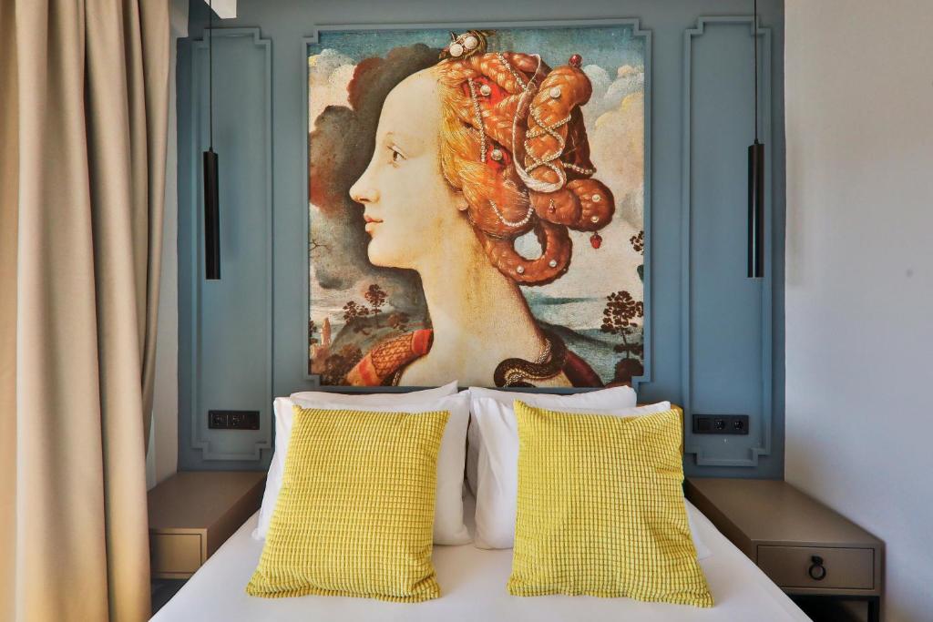 a painting above a bed with two pillows at Neva Kaş in Kaş