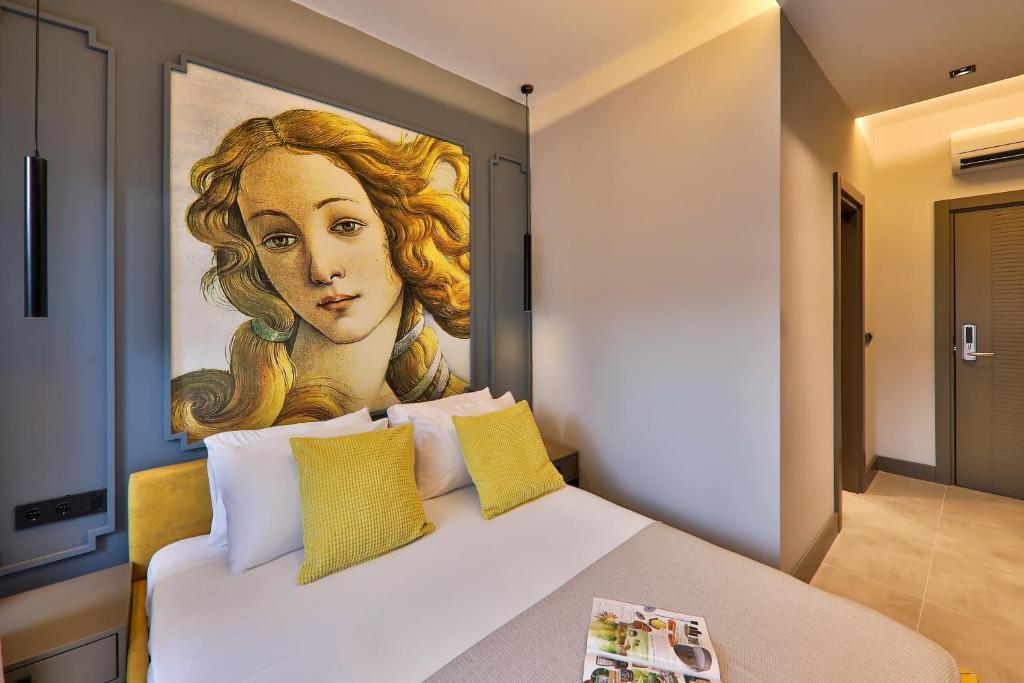 a bedroom with a painting of a woman at Neva Kaş in Kaş