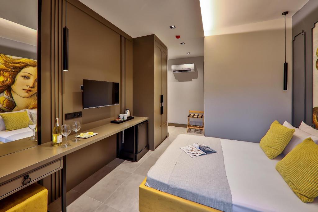 a bedroom with a bed and a desk with a television at Neva Kaş in Kaş