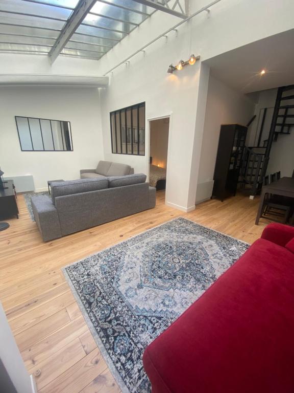 - un salon avec un canapé et un tapis dans l'établissement Loft 3 chambres Bastille, Marais, Père Lachaise, à Paris