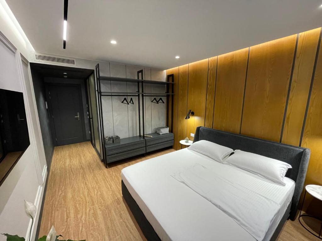 um quarto com uma grande cama branca num quarto em Hotel Europa em Tirana