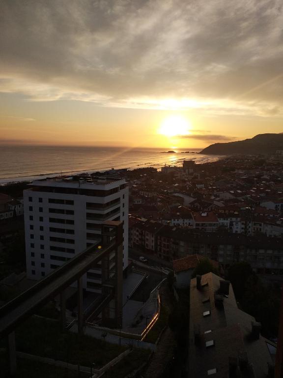 a sunset over the ocean and a city at OFERTA ESPECIAL ÚLTIMA HORA - SARAKATUA15 - vistas espectaculares - familias y parejas - 2 dormitorios independientes - amplio salón cocina comedor - tarjeta parking OTA GRATIS - Julio y agosto estancia mínima 7 noches de domingo a domingo - in Zarautz