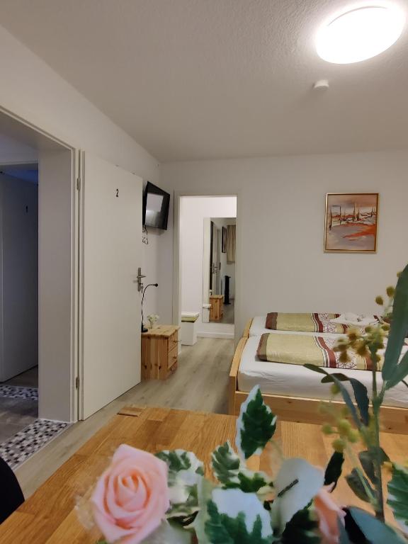 a room with a bed and a table with a flower on the floor at Unterkunft Ramser in Bad Eilsen