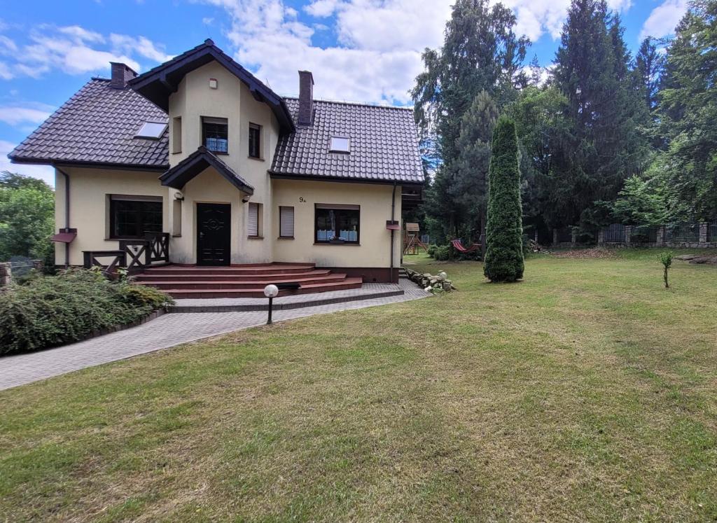 a house with a porch and a grass yard at Dom Majka z 5 sypialniami in Szklarska Poręba