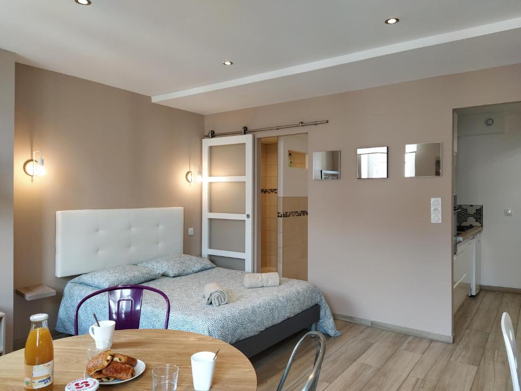 une petite pièce avec un lit et une table dans l'établissement Baiona Sainte Cath -4-Lau- au cœur de Saint Esprit, à Bayonne