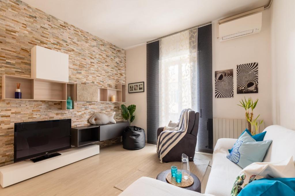 salon ze ścianą z cegły w obiekcie Noi 2 Vacanze al Mare - ARGENTARIO w mieście Porto Santo Stefano