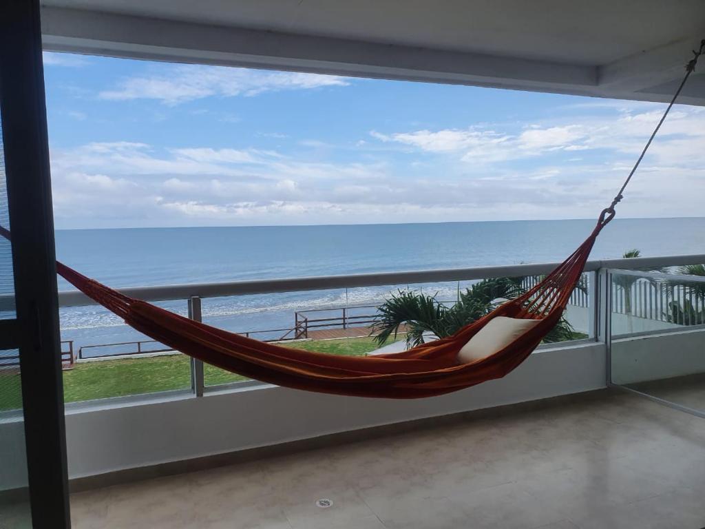 a hammock on a balcony with a view of the ocean at Tonsupa-Edificio MIRASOL in Tonsupa