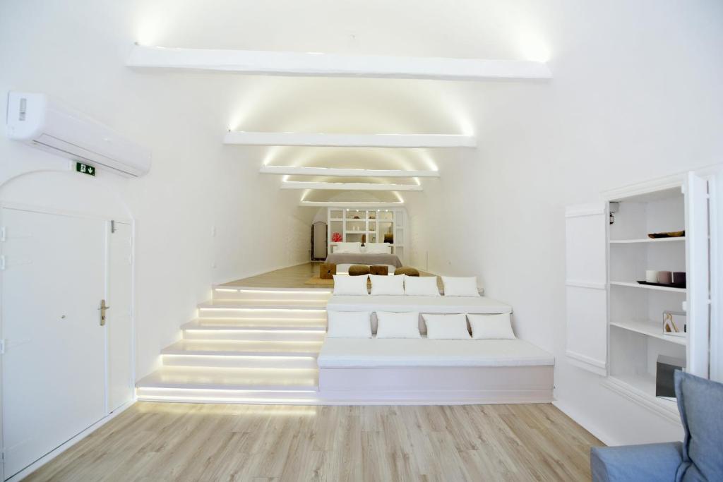Zimmer mit einer Reihe weißer Betten in der Unterkunft Hydra Hospitality Port Apartment in Hydra