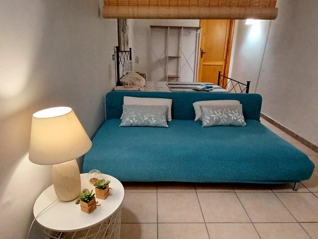 Sofá azul en la sala de estar con lámpara en Casa di Zio, en Alghero