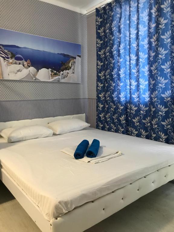 a bed with two blue slippers on top of it at Santorini Odesa in Odesa