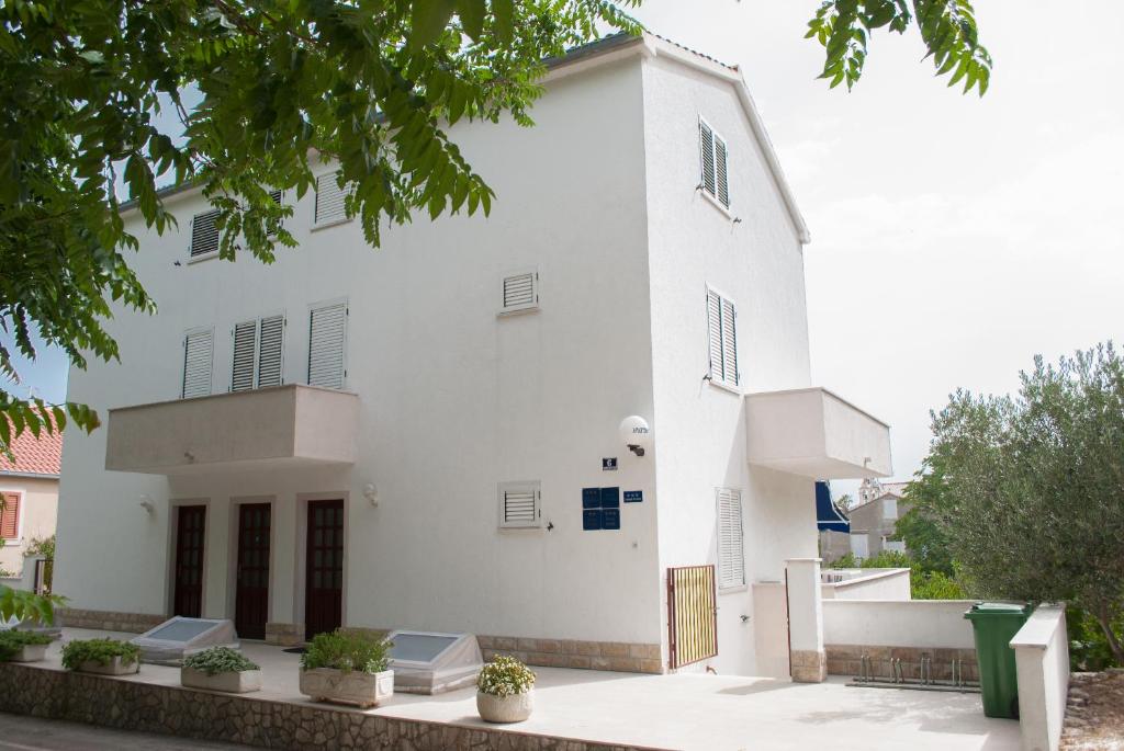 ein weißes Gebäude mit Pflanzen davor in der Unterkunft Apartments Dilk in Vis