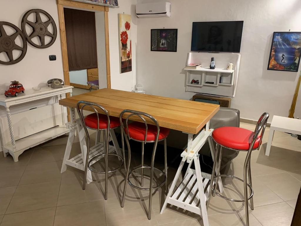 コペルティーノにあるVillaGaudì City Roomsのキッチン(木製テーブル、スツール4脚付)