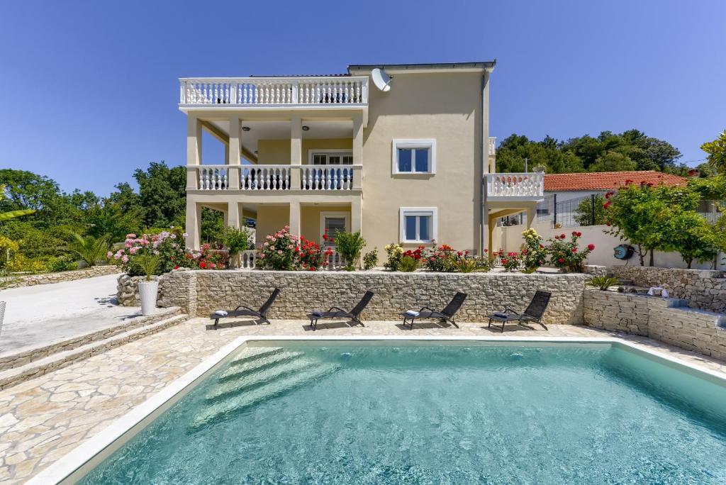 une villa avec une piscine en face d'une maison dans l'établissement Haus Lilli mit Pool, à Ražanac