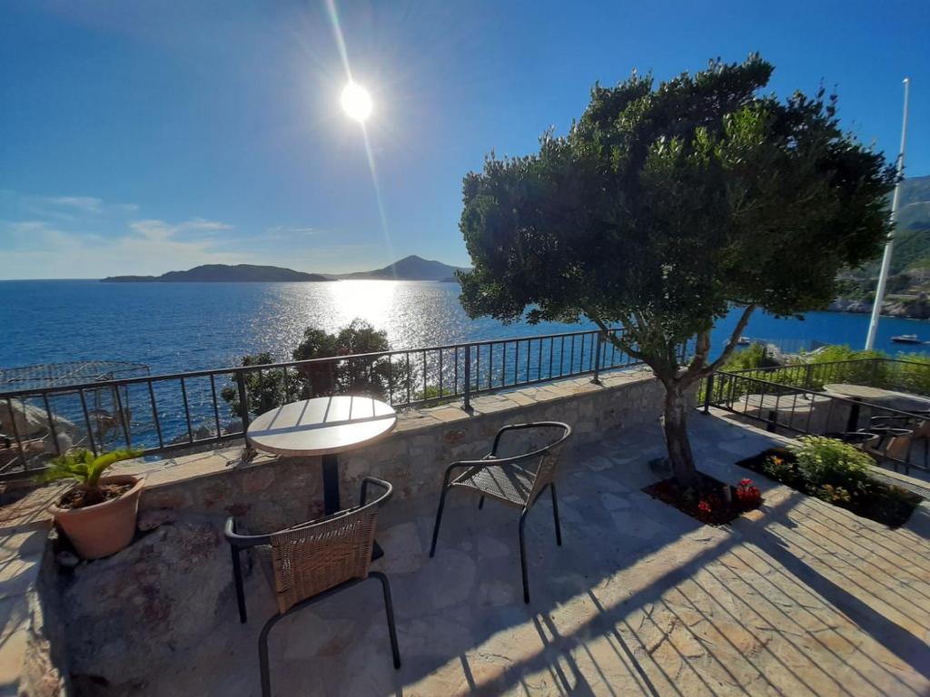 a patio with a table and chairs and the ocean at Apartments Mitrovići Miločer in Sveti Stefan