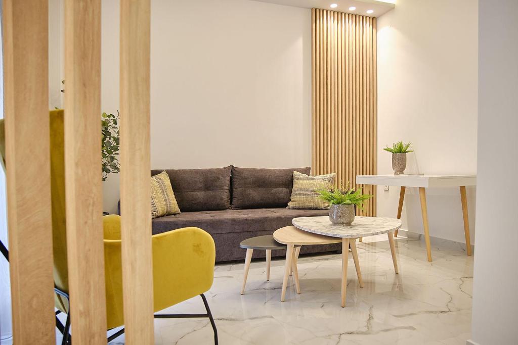 een woonkamer met een bank en een tafel bij Elegant Central Apartment Veria - με ενδοδαπέδια θέρμανση!!! in Veria