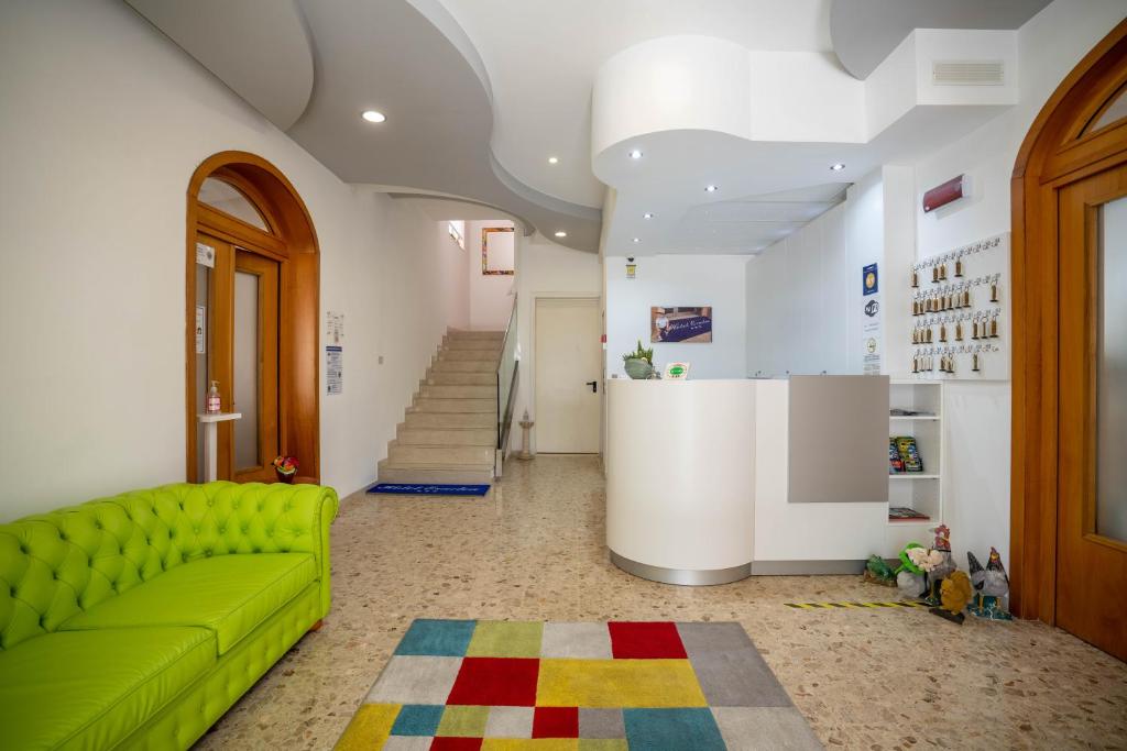 uma sala de estar com um sofá verde e uma escada em Hotel Eraclea em Lido di Jesolo