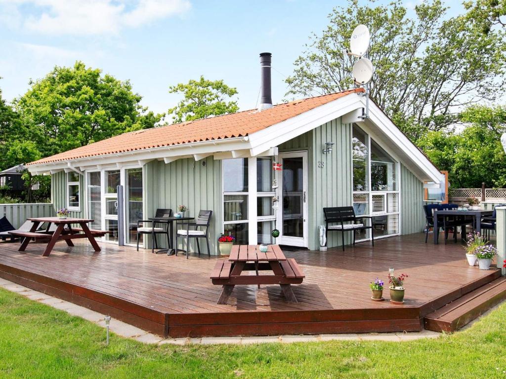 フレデリクスハウンにある6 person holiday home in Frederikshavnのデッキとピクニックテーブル付きの家