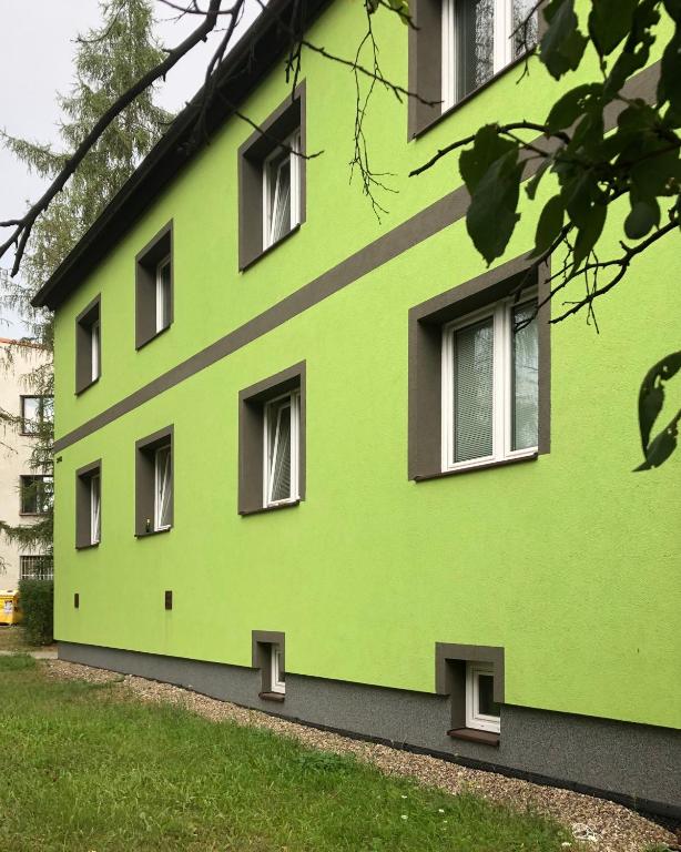 a green building with windows on the side of it at Apartmány - Školní in Chomutov