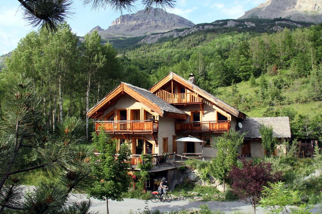 una cabaña de madera con una montaña en el fondo en La Paille, en Pelvoux