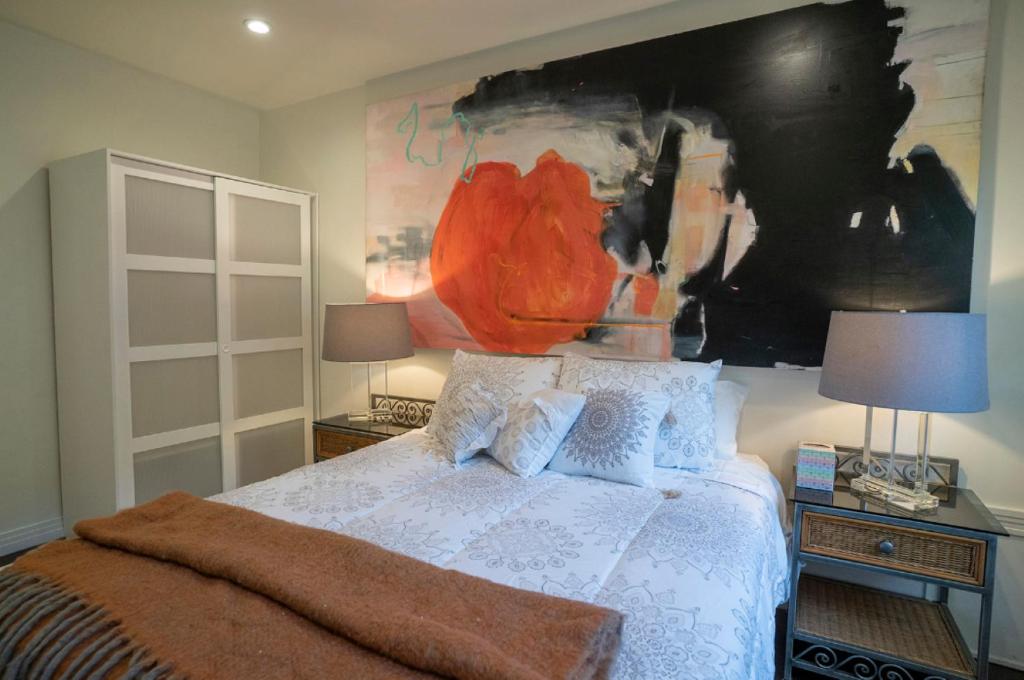 a bedroom with a bed and a painting on the wall at Cozy Suite near Universal Studios in Los Angeles